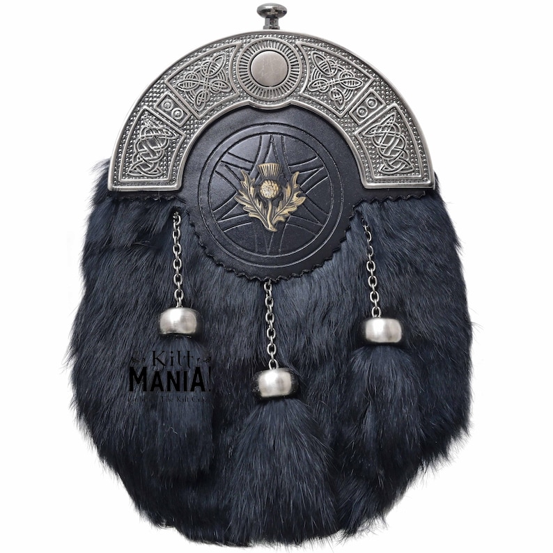 Puede incluir: Un sporran de cuero negro con un cantle plateado con nudos celtas. El sporran tiene un cuerpo de piel, un emblema de cardo y tres borlas plateadas colgando de cadenas. El texto "Kilt Mania" es visible en la parte inferior.