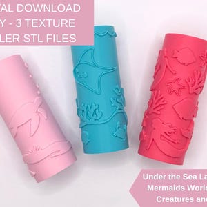 May include: Three cylindrical texture rollers featuring embossed ocean designs. The light pink roller shows a sea turtle, the blue roller displays a stingray and coral, and the bright pink roller features mermaids, fish, and starfish patterns.
