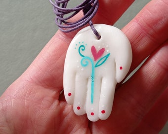 Collana con ciondolo a forma di mano in porcellana fredda e cuore fiorito nel palmo, dipinto a mano.
