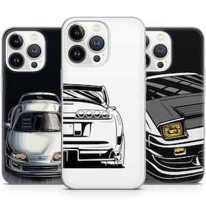 Peut inclure: Trois coques de téléphone avec des designs de voitures. L'une est noire avec une voiture argentée, une autre est blanche avec une illustration de voiture en noir et blanc, et la troisième est noire avec une illustration de voiture grise et jaune. Les coques sont conçues pour un smartphone.