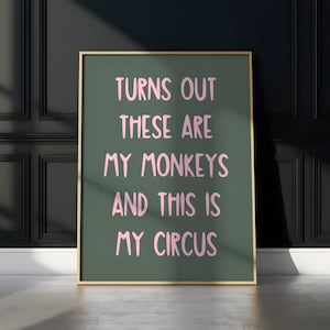 Może przedstawiać: Zielony plakat z pozłacanym obramowaniem zawiera napis "Turns out these are my monkeys and this is my circus" w różowych literach.