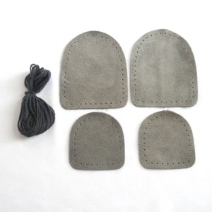 May include: Four gray suede leather patches with stitching around the edges and a ball of gray thread.