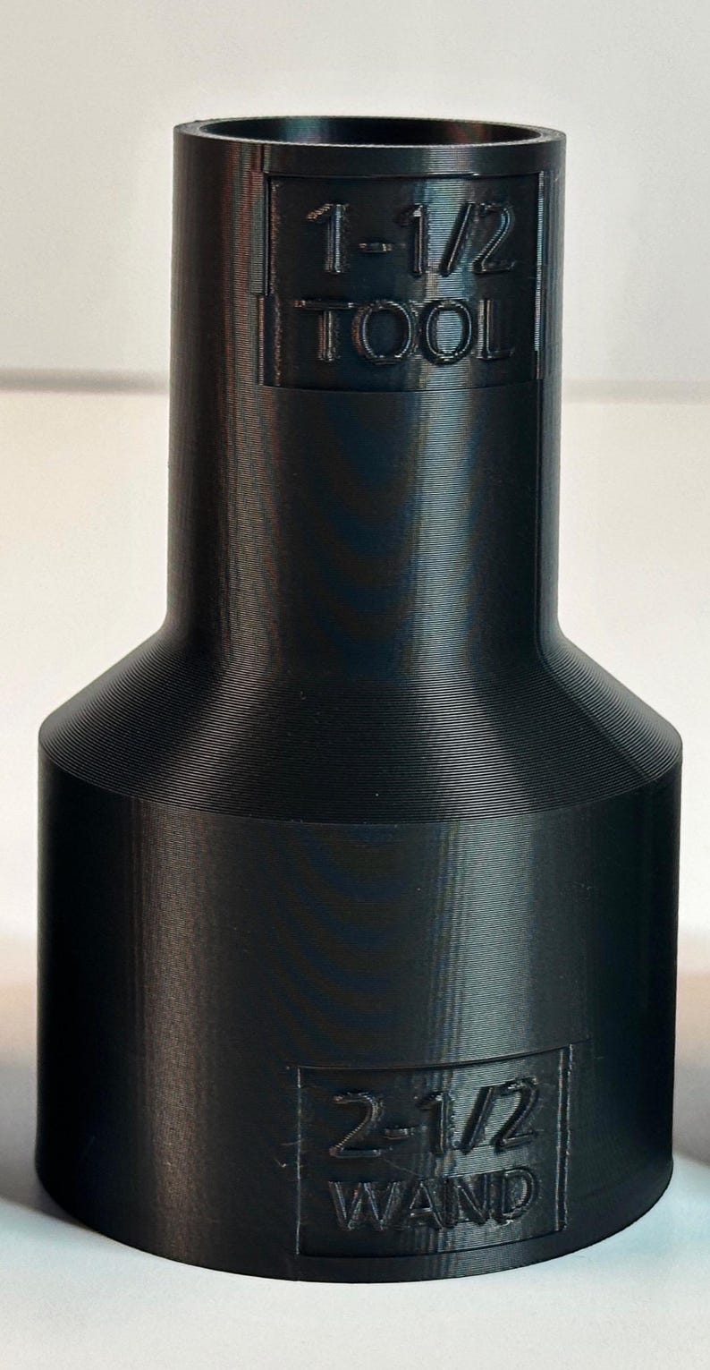 May include: Black plastic adapter with the text "1-1/2 TOOL" and "2-1/2 WAND" printed on it.
