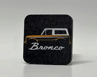 Peut inclure: Sous-verre carré noir avec un contour blanc d'un Ford Bronco vintage et le mot "Bronco" en lettres blanches.