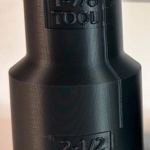 May include: Black plastic adapter with the text "1-7/8 TOOL" and "2-1/2 WAND" printed on it.