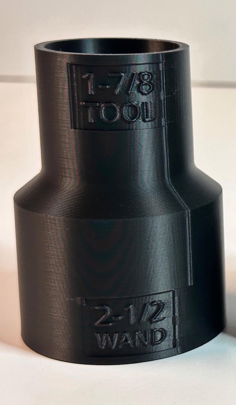 May include: Black plastic adapter with the text "1-7/8 TOOL" and "2-1/2 WAND" printed on it.