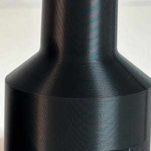 May include: Black plastic 3D printed adapter with the text "1-1/4 TOOL" and "2 1/2 WAND" printed on it.