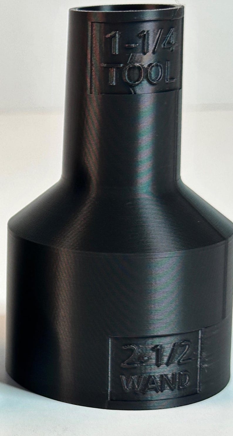 May include: Black plastic 3D printed adapter with the text "1-1/4 TOOL" and "2 1/2 WAND" printed on it.