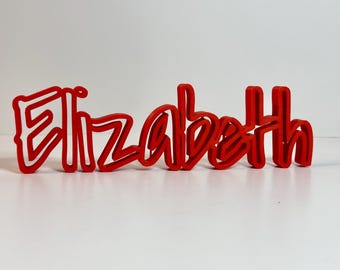 Peut inclure: Un panneau de nom 3D rouge orthographiant "Elizabeth" dans une police audacieuse et stylisée.