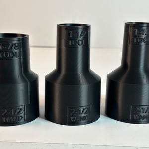 May include: Three black plastic adapters with different sizes. The adapters are labeled with the text "TOOL" and "WAND" and the size of the adapter. The sizes are 1-1/2, 1-1/4, and 1-7/8 inches.