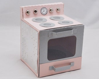 May include: A pink and gray toy stove with a clock on the top and four burner elements. The oven door has a window and a silver handle.