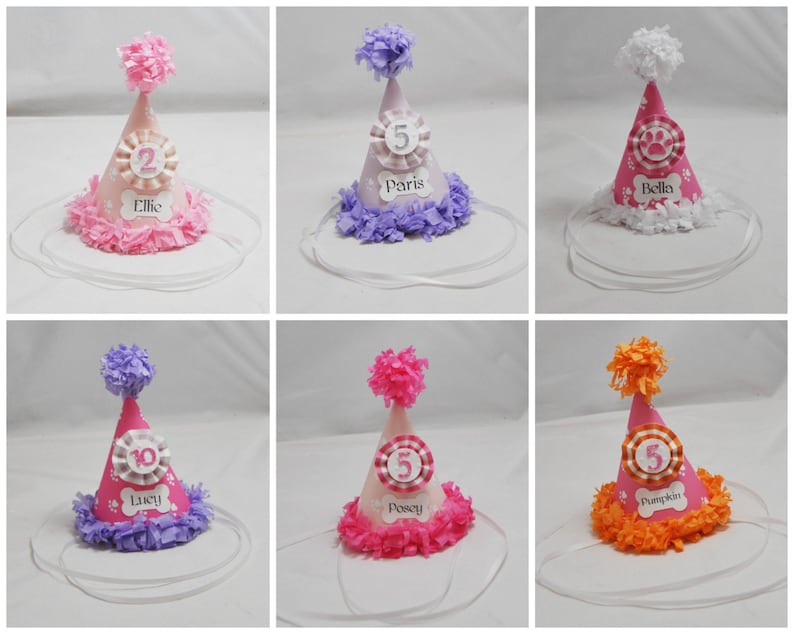 May include: Set of ten pink, purple, and orange dog party hats with white paw print designs. Each hat has a white ribbon, a white pom-pom, and a white circle with a number and a name. The names are Ellie, Paris, Bella, Lucy, Posey, Pumpkin.