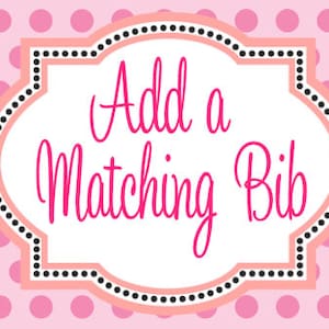 May include: Pink and white sign with black polka dots and a peach border. The sign says "Add a Matching Bib" in pink cursive text.