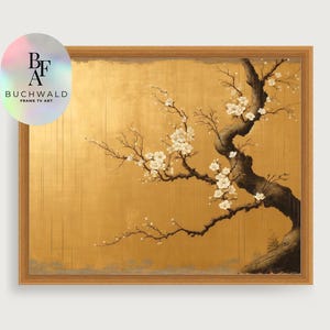 May include: A framed artwork with a gold background and a stylized tree branch with white blossoms. The dark trunk and branches of the tree contrast with the gold. The artwork is framed in a light brown wooden frame. The logo "BUCHWALD FRAME TV ART" is in the upper left corner.