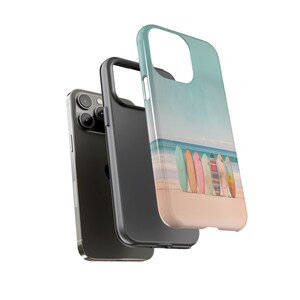A white background with an image of 3 layers. The back layer is an iPhone, the middle layer is a black TPU liner and the top layer is a rigid case with a design of surfboards standing on a beach by the ocean