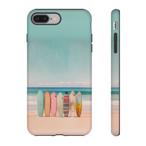 A white background with an iPhone face front on the left side and a side view of the iPhone on the right side. The image on the iPhone is of surfboards standing on a beach by the ocean
