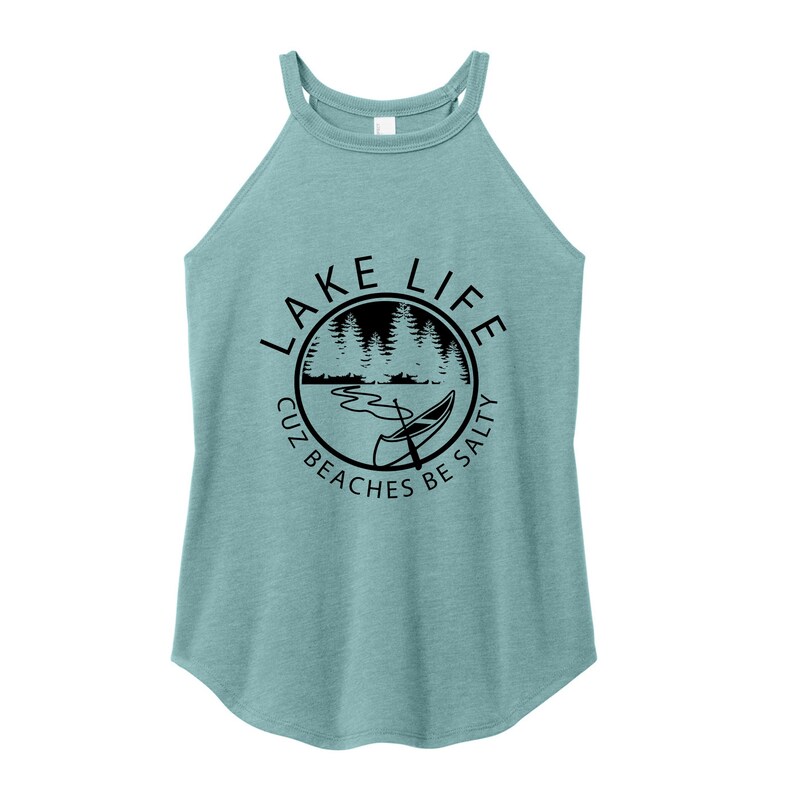 May include: A light teal halter top with a round graphic that says "Lake Life" with a lake scene and a canoe. The text around the graphic says "Cuz Beaches Be Salty".