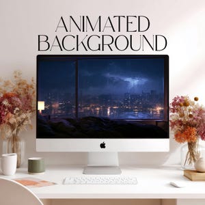 May include: A silver desktop computer monitor displays a dark, stormy night cityscape with lightning over a bedroom interior. The text "ANIMATED BACKGROUND" appears in black above the screen. A white keyboard sits on the desk below.