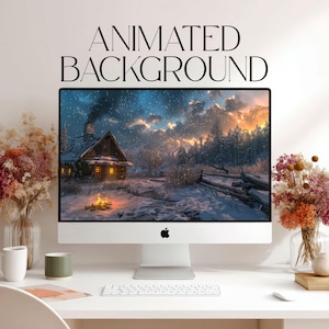 Op de afbeelding: Een computermonitor met een winterlandschap met een blokhut, een kampvuur en vallende sneeuw. De tekst 'ANIMATED BACKGROUND' staat boven het scherm. De monitor staat op een wit bureau met gedroogde bloemstukken.