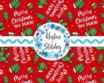 May include: Red background fabric with a repeating pattern of green cacti wearing Santa hats, with the text "Merry Christmas, YOU PRICK!". A blue floral wreath and the text "Kristen in Stitches" are also present.