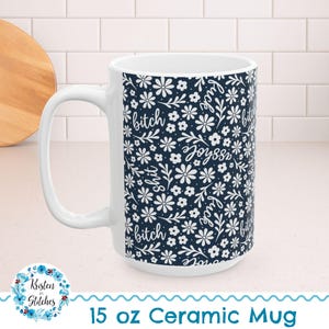 May include: White ceramic mug with a navy blue floral pattern and the words "bitch", "joyass", and "fuck" in white script. The mug is labeled "15 oz Ceramic Mug".