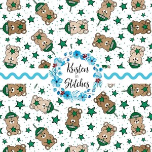 May include: A repeating pattern featuring cartoon teddy bears holding coffee cups, green stars, and tiny white dots on a white background. The bears wear green hats with the word "Barista" on them. A floral wreath with the text "Kristen in Stitches" is also present.