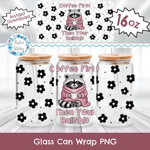 May include: Clear glass can with a bamboo lid and straw, decorated with black flower patterns. The can features a raccoon graphic wearing a pink sweater and holding a mug, with the text "Coffee First, Then Your Bullshit". The can is 16 oz.