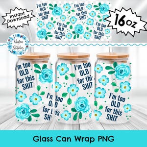 Pode incluir: Três embalagens de latas de vidro com tampas de madeira, cada uma com um design floral com flores turquesas e o texto "I'm too OLD for this SHIT". Um padrão correspondente está acima das latas. A imagem também inclui um rótulo "16oz".