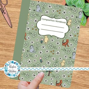 May include: A composition notebook with a green cover featuring a floral pattern and cartoon characters. The notebook has the words "Composition Notebook" on the front. The design includes Winnie the Pooh, Piglet, Tigger, and Eeyore.
