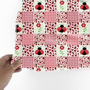 May include: A patchwork design featuring red gingham squares, ladybugs, and red flowers on a light green background. The ladybugs have red wings with black spots. The words "LOVE BUG" are printed on some squares.