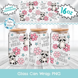 May include: Three glass can wraps with wooden lids, each featuring a raccoon illustration, pink flowers, and the text "Cute but Feral." The design includes stars and the words "Glass Can Wrap PNG."