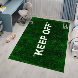 May include: Green area rug with the text "KEEP OFF" in white lettering. The rug has a short, plush pile.