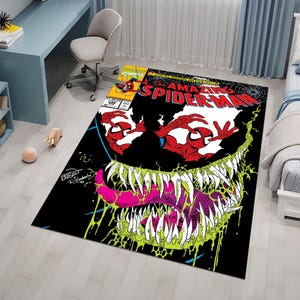 May include: A black and green rug with a comic book design featuring Venom and Spider-Man. The rug has the text "The Amazing Spider-Man" and "Venom" printed on it.