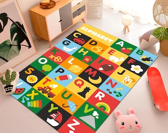 May include: A colorful alphabet play mat with a black background and colorful squares featuring letters, numbers, and illustrations. The mat is labeled "Alphabet".