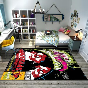 May include: A black and white rug with a comic book design featuring Spider-Man and Venom. The rug has a yellow border and the words "Amazing Spider-Man" are printed in red and white.