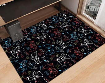 Könnte beinhalten: Schwarz-weißer Teppich mit Gaming-Controller-Muster und bunten Akzenten. Der Teppich zeigt ein sich wiederholendes Muster von Gamecontrollern mit den Worten "Lade", "Gib niemals auf", "Spiel vorbei" und "Level auf" darauf.