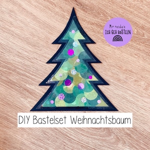 May include: A handmade Christmas tree decoration with a dark blue outline, filled with green and yellow circular patterns and decorated with pink and silver glitter dots. The text "DIY Bastelset Weihnachtsbaum" is at the bottom.