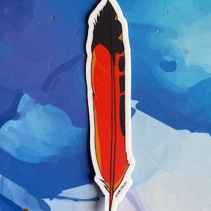 Puede incluir: Una pegatina de pluma de pájaro roja, negra y naranja con borde blanco. La pegatina tiene el texto "@NWY.Mojo" en la parte inferior.