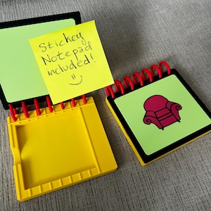 May include: A set of three notebooks with a yellow, green, and black color scheme. One notebook has a yellow sticky note that says "Sticky Notepad included!" with a smiley face. The other notebook has a red armchair graphic.