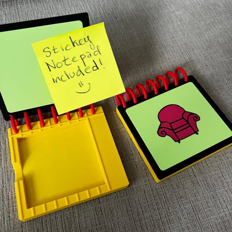 May include: A set of three notebooks with a yellow, green, and black color scheme. One notebook has a yellow sticky note that says "Sticky Notepad included!" with a smiley face. The other notebook has a red armchair graphic.
