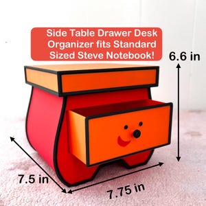 May include: A red and orange side table drawer desk organizer with a smiling face on the drawer. The dimensions are 7.75 in wide, 7.5 in deep, and 6.6 in high. The text on the image says "Side Table Drawer Desk Organizer fits Standard Sized Steve Notebook!"