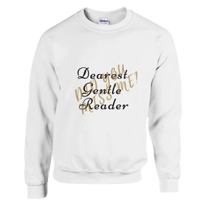Könnte beinhalten: Weißer Langarm-Pullover mit dem Aufdruck "Dearest Gentle Reader" in Schwarz und Gold.