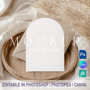 May include: A white arch-shaped card mockup placed on a light beige envelope inside a round wooden tray. The card features the text MOCKUP PSD + JPG + PNG. Additional icons for Photoshop, Canva, and Photopea are visible, with text stating EDITABLE IN PHOTOSHOP | PHOTOPEA | CANVA.