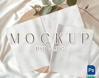 Puede incluir: Una maqueta con tres hojas de papel blanco dispuestas sobre una superficie de madera, con la palabra "MOCKUP" en una fuente serif. La imagen incluye el texto "PSD + JPG" y una ramita de eucalipto. El fondo es una tela blanca texturizada.