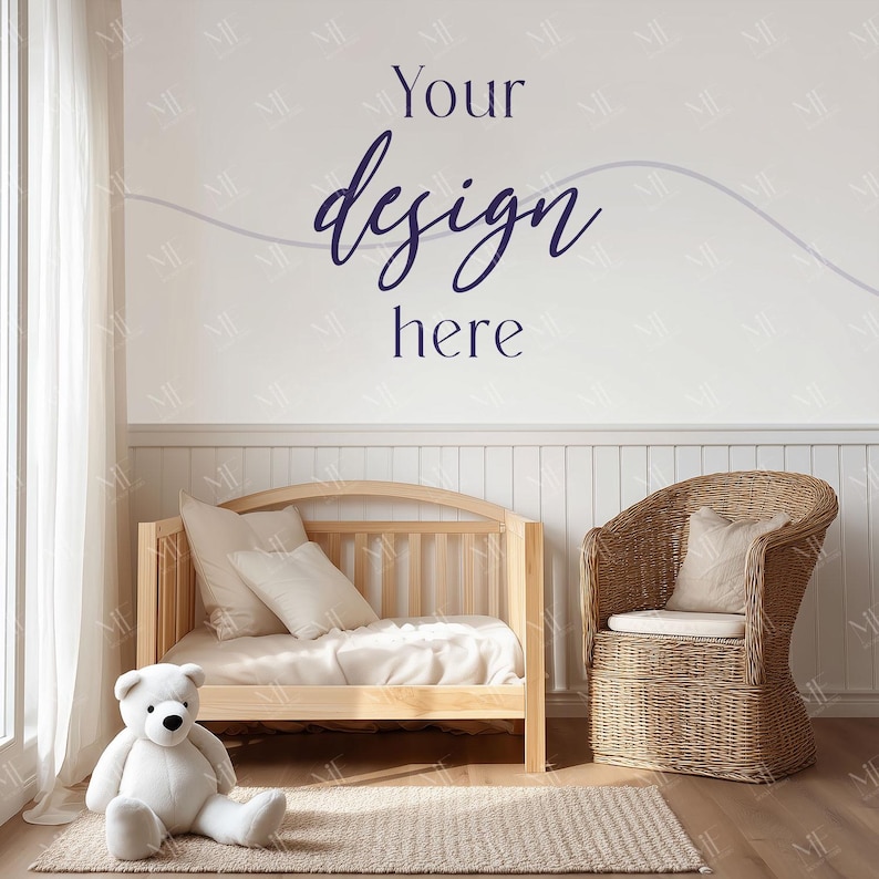 May include: A light wood crib with bedding and pillows, a wicker chair with a cushion, and a plush white teddy bear on a rug. The wall has the text "Your design here" in navy blue script.