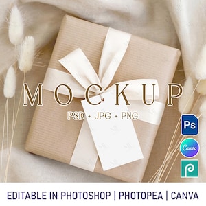 May include: A wrapped gift box with a cream-colored ribbon and tag. The box is wrapped in brown paper and the ribbon is tied in a bow. The word "MOCKUP" is displayed on the box. The text "PSD + JPG + PNG" is also visible. The image includes icons for Photoshop, Canva, and Photopea.
