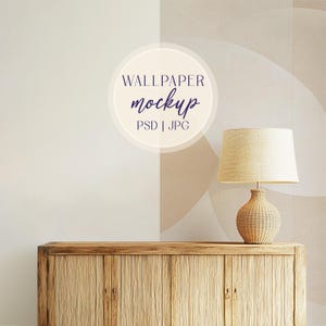 Puede incluir: Un armario de madera con dos puertas se encuentra frente a una pared beige con un patrón abstracto marrón claro y blanco. Una lámpara con una pantalla beige se encuentra encima del armario. El texto "WALLPAPER MOCKUP PSD | JPG" está en un círculo en la pared.