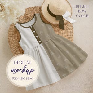 Peut inclure: Robe sans manches avec un design bicolore blanc et beige, agrémentée d'une bordure et de boutons vert olive. La robe est présentée avec un chapeau de paille. Le texte "DIGITAL mockup PSD | JPG | PNG" est visible.