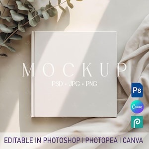 May include: A square, off-white book mockup with the word "MOCKUP" in a light font. The text "PSD + JPG + PNG" is below. The words "EDITABLE IN PHOTOSHOP | PHOTOPEA | CANVA" are at the bottom. A leaf and fabric are in the background.