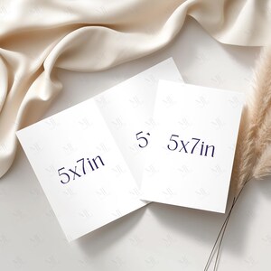 May include: Three white 5x7 inch cards with dark blue text, arranged on a white surface with a cream-colored fabric and dried plant accents. The cards are rectangular and the text indicates their dimensions.